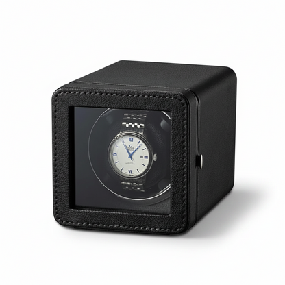 Remontoir de montre automatique noir en forme de cube avec finition texturée et fenêtre de visualisation transparente.