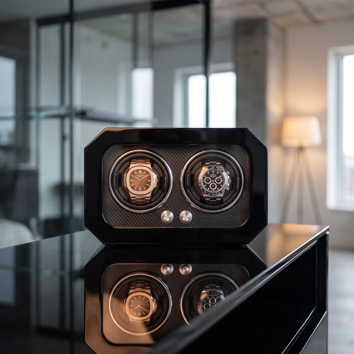 Remontoir noir pour 2 montres en fibre de carbone avec éclairage LED, design moderne et élégant posé sur une table.