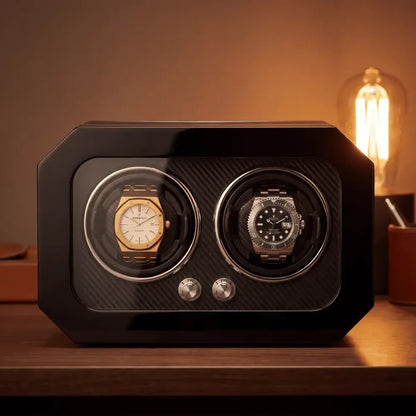 Remontoir noir en fibre de carbone pour deux montres automatiques avec façade en verre et boutons de contrôle argentés.