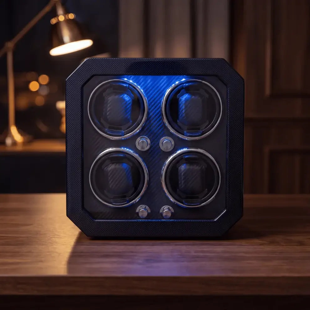 Remontoir pour 4 montres en fibre de carbone noire avec éclairage LED bleu, design moderne et élégant sur une table en bois.