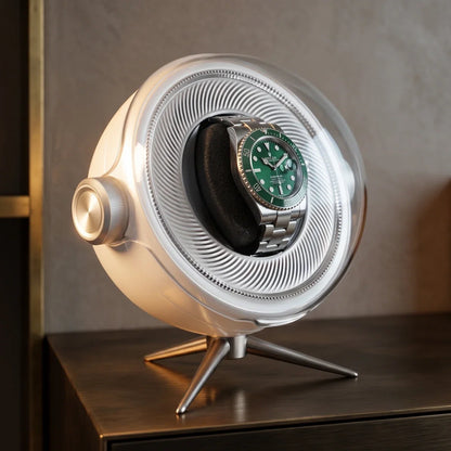 Remontoir automatique Tripode Solo blanc au design sphérique moderne avec une montre à cadran vert sur son support.