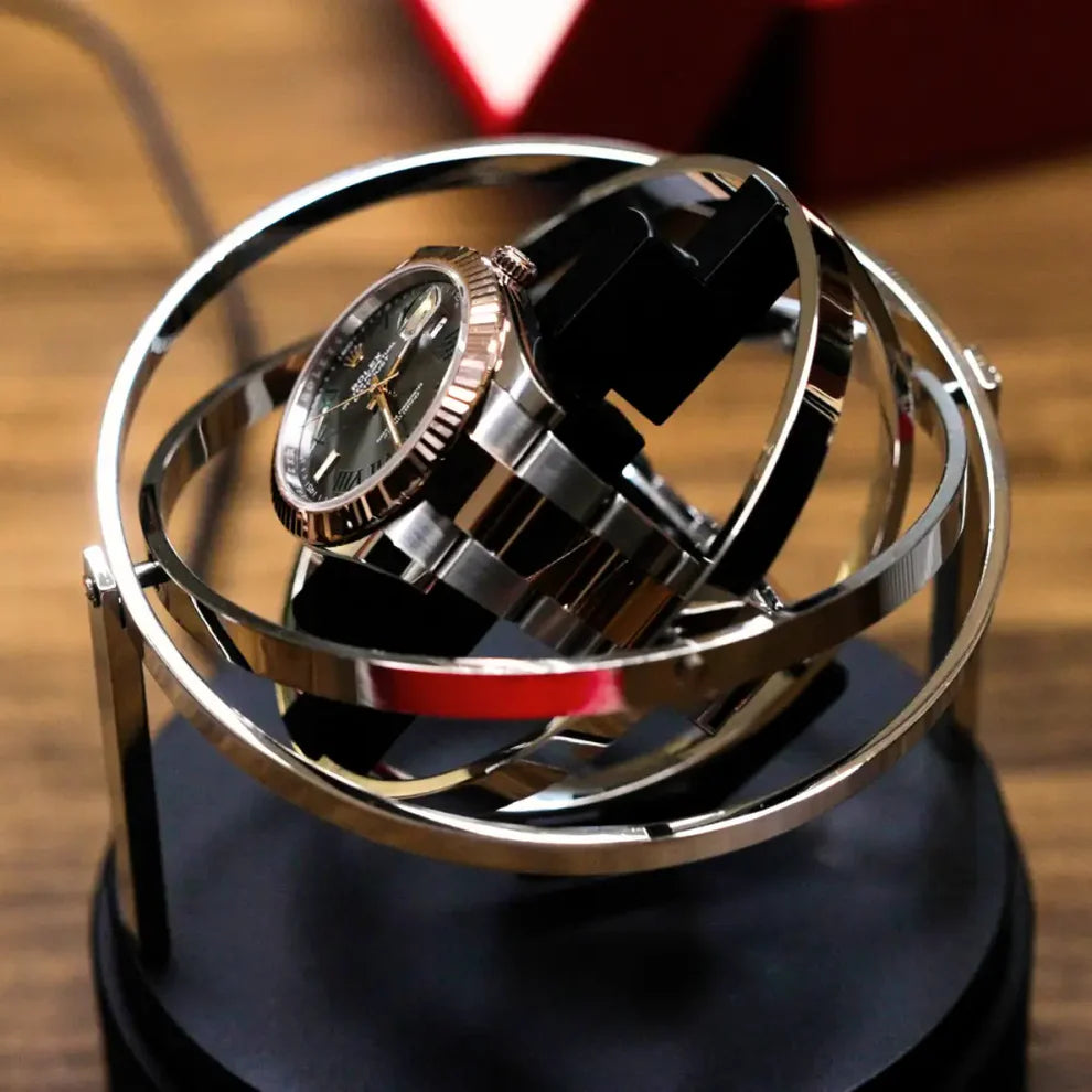 Remontoir montre automatique Astronome argenté en acier inoxydable avec design gyroscopique rotatif sur socle noir.